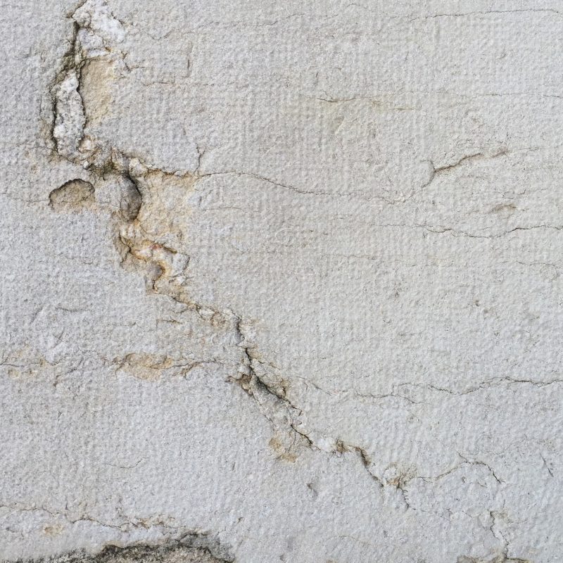 Crack in a wall exposing concrete and gravel